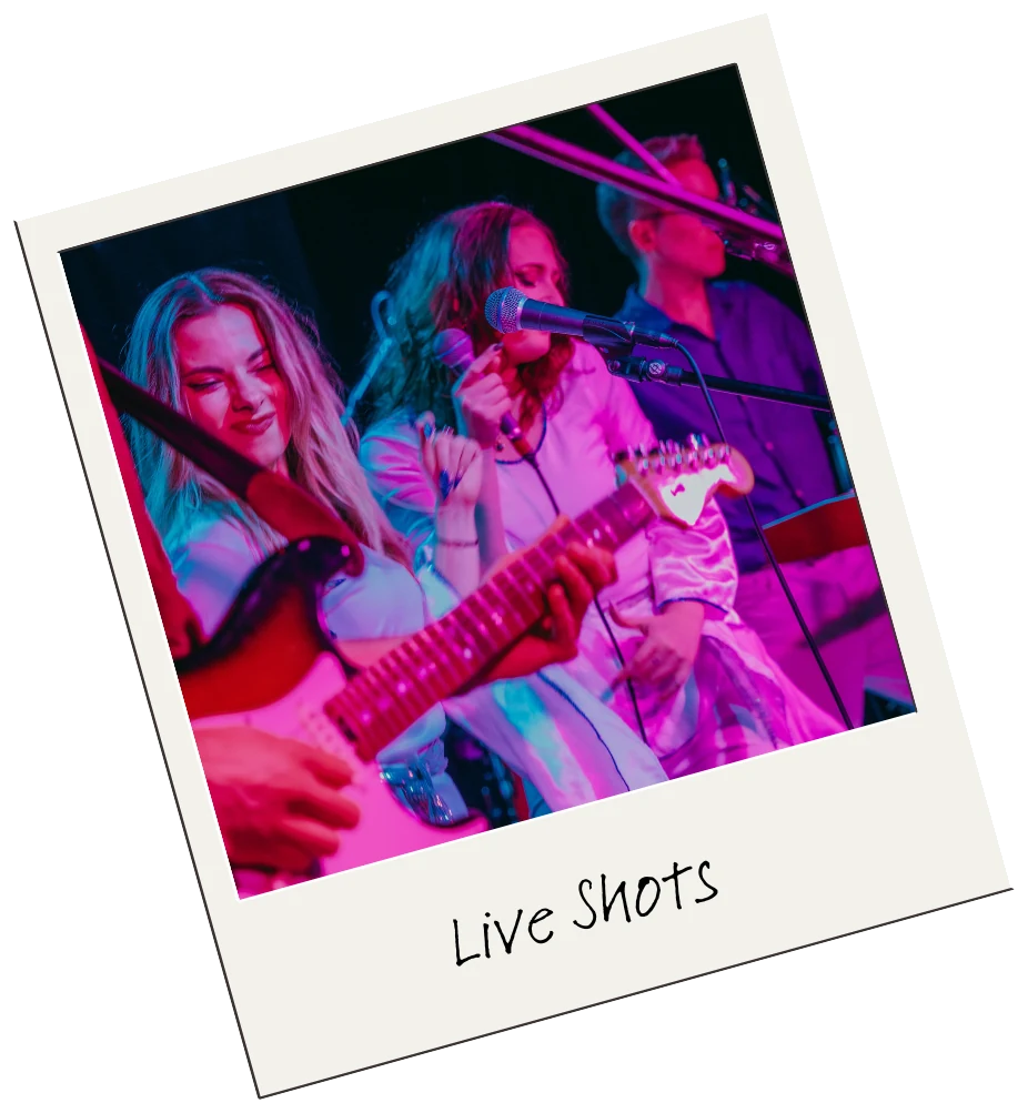Guitarist performing beneath pink stage lights