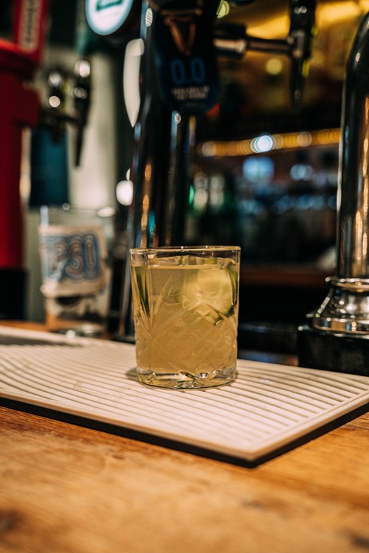 Cocktail served on a bar beneath the taps