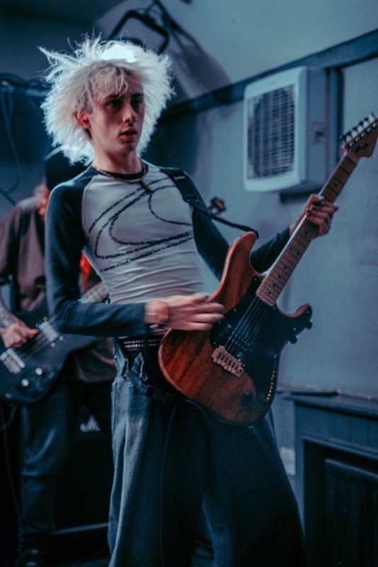 Guitarist performing under cool blue stage lights